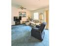 Comfortable living room features plush carpeting and a cozy seating arrangement at 2105 Escobar Ave, The Villages, FL 32159