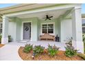 Inviting front porch with stylish seating, decorative wreath, and well-maintained landscaping at 2163 County Road 243F, Wildwood, FL 34785