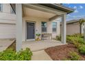 Charming front porch featuring a modern door, lush landscaping, and room for seating at 2350 Gold Dust Dr, Clermont, FL 34715