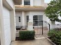 Front entrance showcasing brick-paved patio enclosed by a decorative metal gate and manicured bushes at 2450 Sweetwater Country Club Dr, Apopka, FL 32712