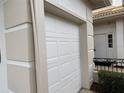 Attached garage with white paneled door and light-colored trim at 2450 Sweetwater Country Club Dr, Apopka, FL 32712