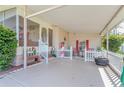 Inviting covered porch with charming decorations, including a picket fence, seating, and views of the street at 2475 Karen Dr, Mount Dora, FL 32757