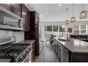Modern kitchen featuring stainless steel appliances and a spacious island with barstool seating at 2532 Autumn Stream Dr, Leesburg, FL 34748