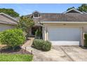 Charming townhome with attached garage, tidy landscaping, and a welcoming facade at 264 Juniper Way, Tavares, FL 32778