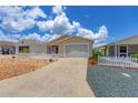 The home features a paved driveway, a garage, a front porch and beautiful landscaping at 2805 Burgos Dr, The Villages, FL 32162