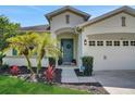 Inviting front entrance featuring a vibrant blue door with lush landscaping at 30532 Gidran Ter, Mount Dora, FL 32757