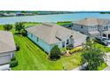 Back of home with lush lawn leads to lake at 313 Blue Cypress Dr, Groveland, FL 34736