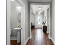 Bright entryway features wood floors, a pendant light, and a view of a half bathroom at 313 Blue Cypress Dr, Groveland, FL 34736