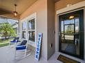 Inviting front porch features a cozy seating area and a 'Welcome' sign, creating a warm entrance at 395 Blue Cypress Dr, Groveland, FL 34736