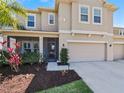 Charming home features a manicured front yard, a covered porch, and a spacious two-car garage at 395 Blue Cypress Dr, Groveland, FL 34736