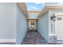 Pathway leads to a welcoming front door with decorative wreath and stylish exterior lighting at 4987 Belted Kingfisher Dr, Oxford, FL 34484