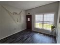 Bright entryway featuring dark wood-look floors, front door, and nautical decor at 504 Se 35Th Ave, Ocala, FL 34471