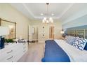 Stylish main bedroom with tray ceiling, a modern light fixture and an ensuite bathroom at 504 Silver Palm Dr, Haines City, FL 33844