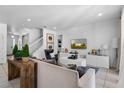 Bright living room with tile floors, modern furniture, and a staircase leading to the upper level at 5241 Oakbourne Ave, Davenport, FL 33837