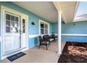 Cozy covered front porch with comfortable seating, columns, and a storm door at 5380 County Road 122, Wildwood, FL 34785