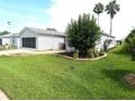 Single-story home with lush green lawn and well-maintained landscaping at 751 Old Oaks Ln, Leesburg, FL 34748