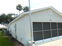 Side view of the home featuring a screened garage door and satellite dish at 751 Old Oaks Ln, Leesburg, FL 34748
