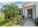 Charming home entrance featuring a well-manicured garden and a decorative glass front door at 8039 Se 174Th Belhaven Loop, The Villages, FL 32162