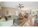 Comfortable living room with hardwood floors, fan, and open layout to the dining area at 8039 Se 174Th Belhaven Loop, The Villages, FL 32162