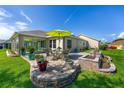 Spacious backyard featuring a brick patio, planting area, and lush green lawn at 9059 Se 177Th Grassmere St, The Villages, FL 32162