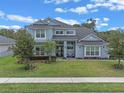 Stunning home with well-manicured lawn, mature trees, and an inviting facade that gives it incredible curb appeal at 9512 Mid Summer Ln, Leesburg, FL 34788