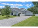 Beautiful home featuring an attached three-car garage with a paved driveway and a well-manicured lawn at 9512 Mid Summer Ln, Leesburg, FL 34788