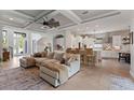 Bright and airy living room featuring tile floors, a coffered ceiling, an oversized fan, and a view of the kitchen at 9512 Mid Summer Ln, Leesburg, FL 34788