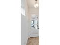 Bright entryway featuring a white door with glass panels and a view to a blue front door at 9674 Rodbell St, Orlando, FL 32827