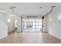 Spacious living room with modern tile flooring, and a glass garage style door leading to the patio at 9674 Rodbell St, Orlando, FL 32827