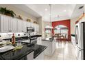 Charming kitchen with white cabinetry, black countertops, island, and adjacent dining area for easy entertaining at 1010 Sierra Blanca Ct, Lady Lake, FL 32159