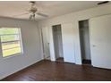 Bedroom with wood-look floors, two closets, and a window bringing in natural light at 1109 Willow Ct, Tavares, FL 32778