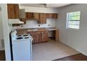 Functional kitchen with vintage wood cabinets, white appliances, and ample counter space at 1109 Willow Ct, Tavares, FL 32778