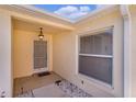Covered front porch featuring a security screen door, hanging light, and white rock at 1116 San Bernardo Rd, The Villages, FL 32162