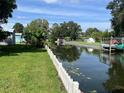 Waterfront view of a canal with lush greenery and a white picket fence running along the shoreline at 11812 Watts Ct, Tavares, FL 32778