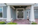 Elegant front door with sidelights, framed by white pillars, and a brick walkway leading to the entrance at 14501 Wabasso Loop, Winter Garden, FL 34787