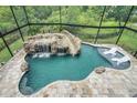 A luxurious screened-in pool with a rock waterfall, slide, and lounge chairs offers a resort-style experience at 14501 Wabasso Loop, Winter Garden, FL 34787