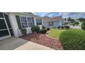Well-maintained lawn with tidy shrubbery adds curb appeal to this lovely home at 1550 Ward Ct, The Villages, FL 32162