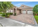 Charming single-Gathering home boasts an arched entryway and a two-car garage with a brick paver driveway at 15531 Waterleigh Cove Dr, Winter Garden, FL 34787
