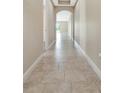 Inviting hallway features neutral paint, tile flooring, archways, and seamlessly connects the home's living spaces at 15531 Waterleigh Cove Dr, Winter Garden, FL 34787