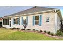 Exterior of home featuring a well-manicured lawn and blue shuttered windows at 1676 Van Buren Way, The Villages, FL 32162