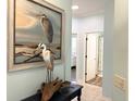 Hallway with tile floors, elegant art, and doorways leading to bedrooms and bathroom, offering a glimpse into the home's layout at 1676 Van Buren Way, The Villages, FL 32162