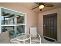 Cozy patio seating area featuring a ceiling fan and dark brown front door at 16827 Se 92Nd Lance Ct, The Villages, FL 32162