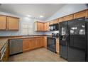 Well-lit kitchen with stainless steel dishwasher and black appliances, complemented by light wood cabinetry at 16827 Se 92Nd Lance Ct, The Villages, FL 32162