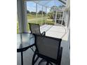 A covered back porch with a table, chairs, and a view of a golf course at 1706 Augustine Dr, The Villages, FL 32159
