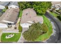 Aerial view of home with lush landscaping, stone paver driveway, and manicured lawn at 17324 Se 82Nd Pecan Ter, The Villages, FL 32162