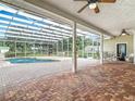 A screened-in pool area with brick pavers, a covered patio, and outdoor seating perfect for relaxation and entertainment at 17670 Se 283Rd Ave, Umatilla, FL 32784