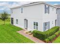 Attractive two-story home featuring lush green grass, a brick pathway, and colorful landscaping at 212 Primrose Dr, Davenport, FL 33837