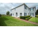 Beautiful two-story home with a well-manicured lawn, brick walkway, and picturesque landscaping at 212 Primrose Dr, Davenport, FL 33837