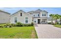 Attractive two-story home with brick driveway, two-car garage, lush landscaping and front entryway at 2147 Timber Creek Ln, Clermont, FL 34715