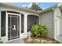 Inviting front entrance with decorative screen door and lush landscaping at 215 Chula Vista Ave, The Villages, FL 32159